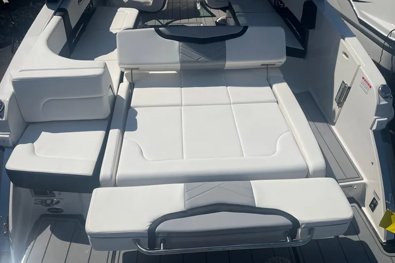Slide: The Image of 2022 Chaparral 307 SSX boat interior with white cushioned seating and sleek design. - 12