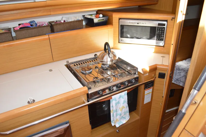 Slide: The Image of Galley kitchen in 2008 Jeanneau Sun Odyssey 45 DS yacht with stove and microwave. - 53