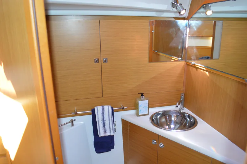 Slide: The Image of Luxurious bathroom in 2008 Jeanneau Sun Odyssey 45 DS yacht with wood cabinetry and stainless steel sink. - 72