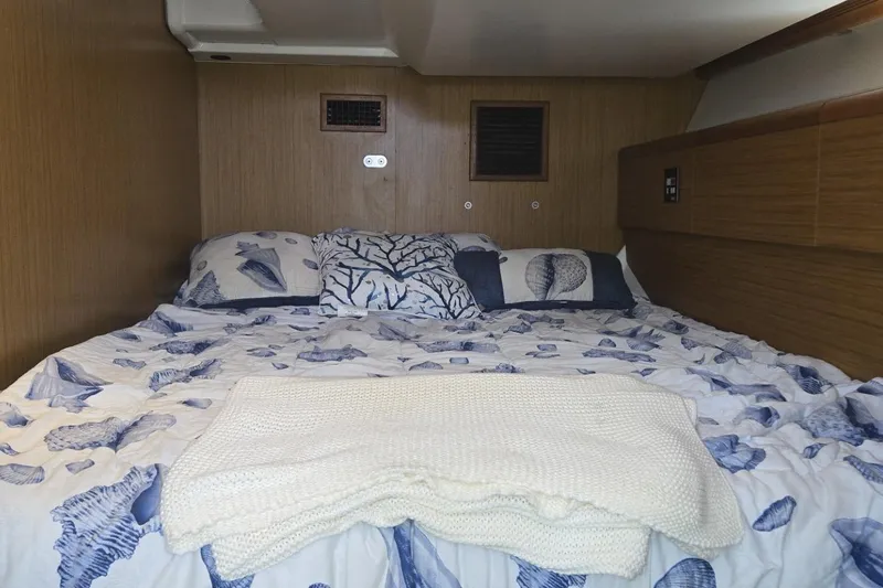 Slide: The Image of Cozy cabin interior of 2008 Jeanneau Sun Odyssey 45 DS with nautical-themed bedding. - 76