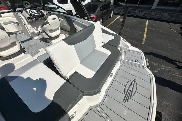 Slide: The Image of 2026 Chaparral 21 SSi boat interior with seating and steering wheel, parked in a lot. - 11