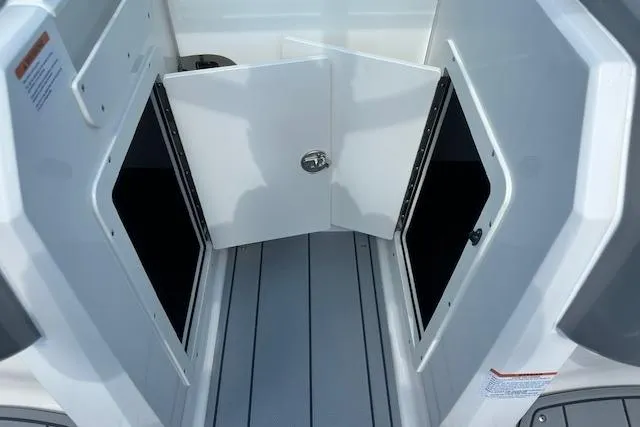 Slide: The Image of 2026 Chaparral 21 SSi boat storage compartment with open doors, showcasing interior space. - 22