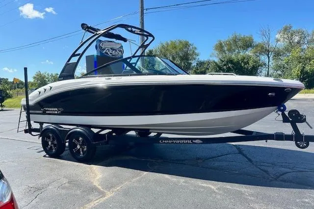 Slide: The Image of 2026 Chaparral 21 SSi boat on trailer, black and white design, parked outdoors. - 3