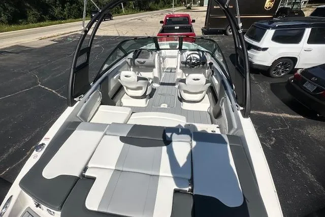 Slide: The Image of 2026 Chaparral 21 SSi boat interior with seating, parked in a lot. - 9