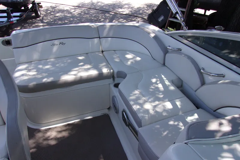 Slide: The Image of 2012 Sea Ray 200 Sundeck interior with white cushioned seating and sleek design. - 7