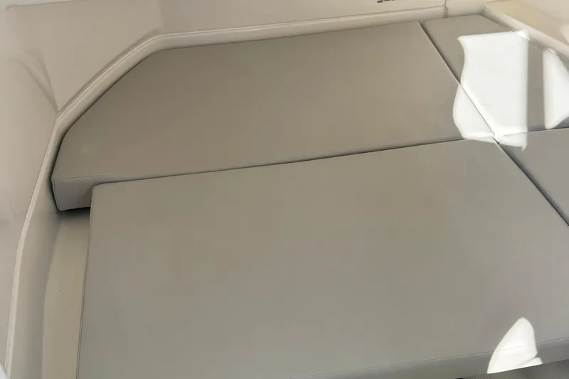 Slide: The Image of 2025 Sea Ray SDX 250 Outboard interior seating with light gray cushions. - 15