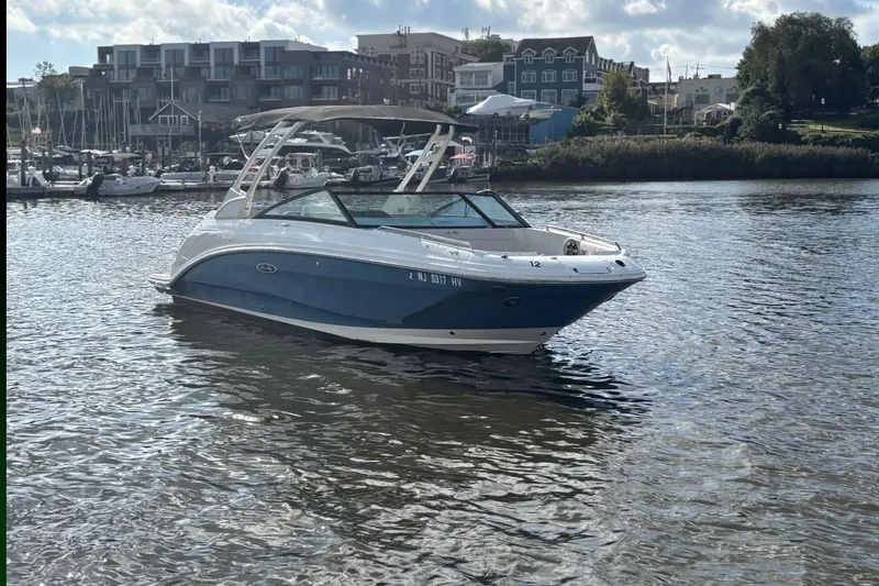 Slide: The Image of 2025 Sea Ray SDX 250 Outboard boat on a calm river with scenic background. - 2