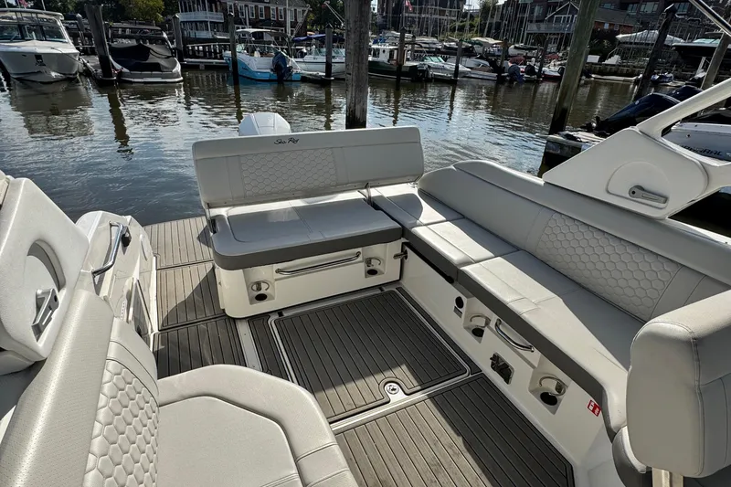 Slide: The Image of 2025 Sea Ray SDX 250 Outboard boat interior with luxurious seating at a marina. - 7
