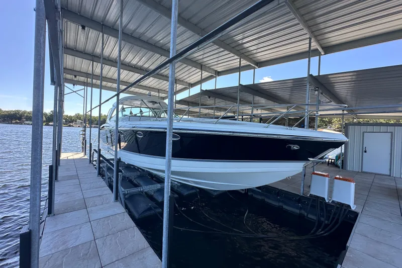 Slide: The Image of 2007 Formula 400 Super Sport boat cruising near a marina under clear blue skies. - 3