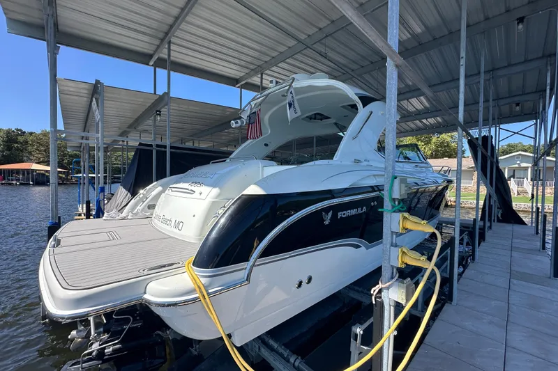 Slide: The Image of 2007 Formula 400 Super Sport boat docked in a marina with scenic background. - 4
