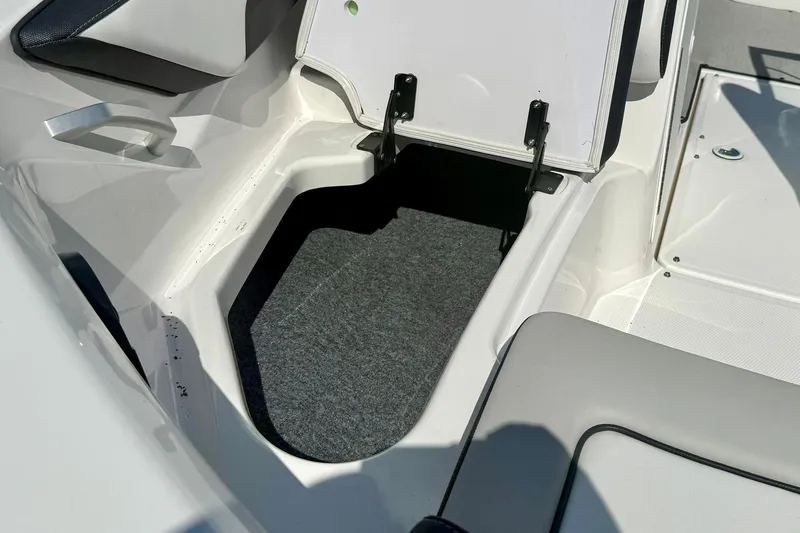 Slide: The Image of 2022 Yamaha Boats SX195 storage compartment with open hatch, showcasing interior space. - 16