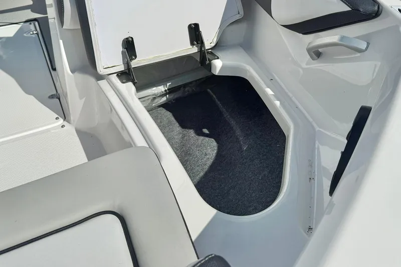 Slide: The Image of 2022 Yamaha Boats SX195 storage compartment with open hatch, showcasing interior space. - 17