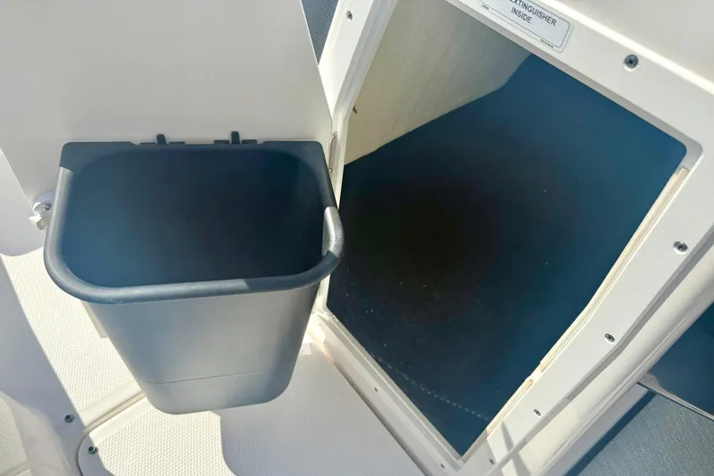 Slide: The Image of 2022 Yamaha SX195 boat storage compartment with trash bin. - 23