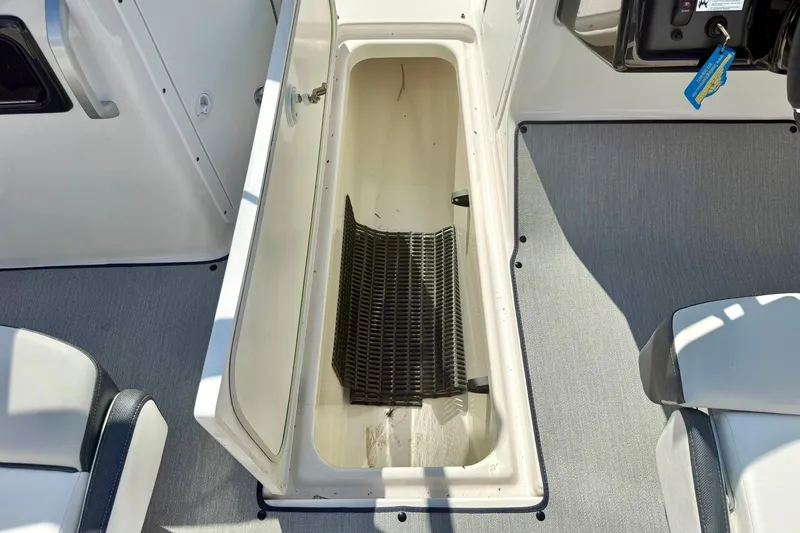 Slide: The Image of 2022 Yamaha Boats SX195 storage compartment with open hatch, showcasing interior space. - 29