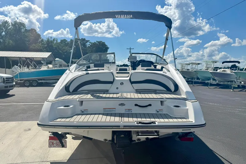 Slide: The Image of 2022 Yamaha Boats SX195, rear view, parked in marina under blue sky. - 37