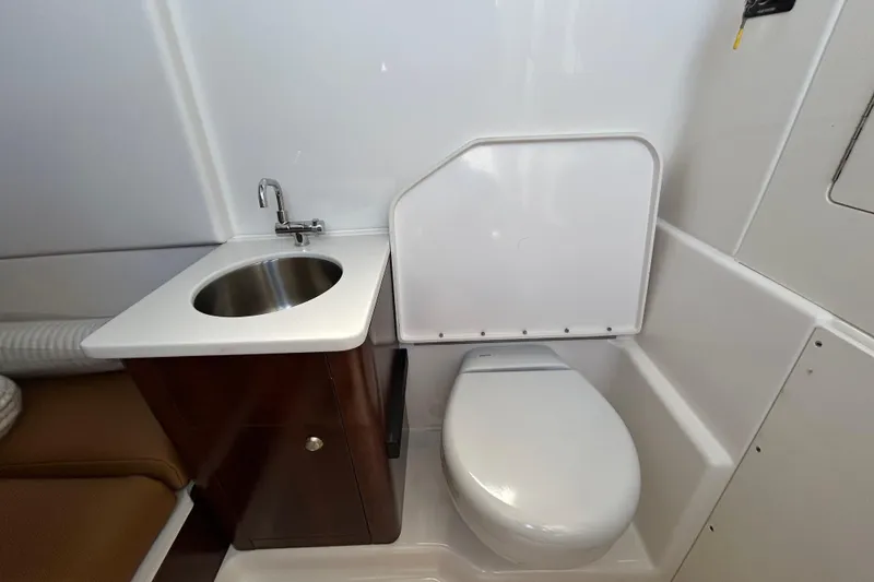 Slide: The Image of 2026 Robalo R360 Center Console boat bathroom with sink and toilet. - 19