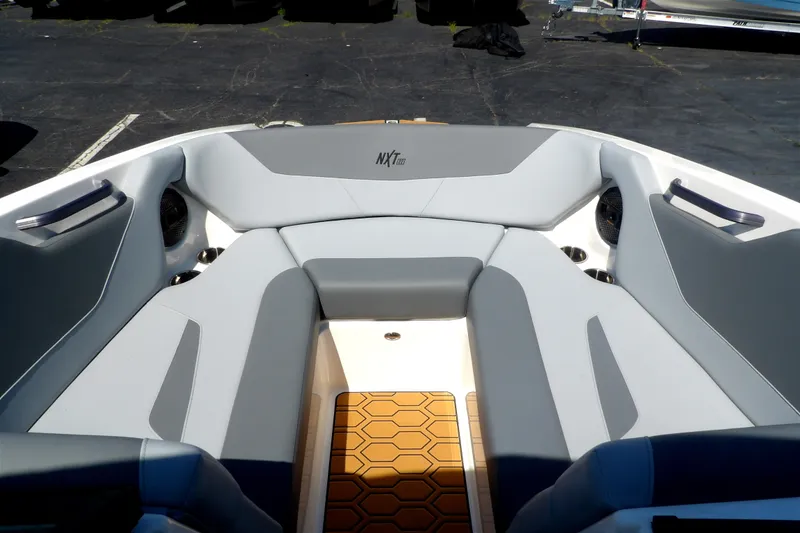 Slide: The Image of 2023 MasterCraft NXT22 boat interior with gray seating and teak-style flooring. - 5