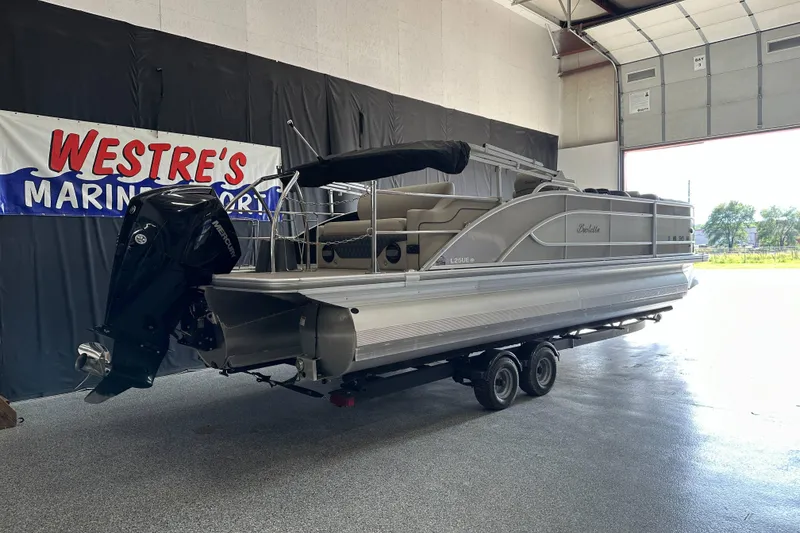 Slide: The Image of 2020 Barletta L25UE pontoon boat in showroom, featuring a powerful outboard motor. - 3