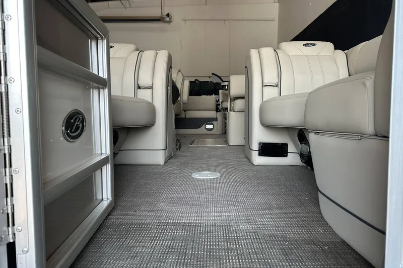 Slide: The Image of 2020 Barletta L25UE pontoon boat with Mercury engine in showroom setting. - 6