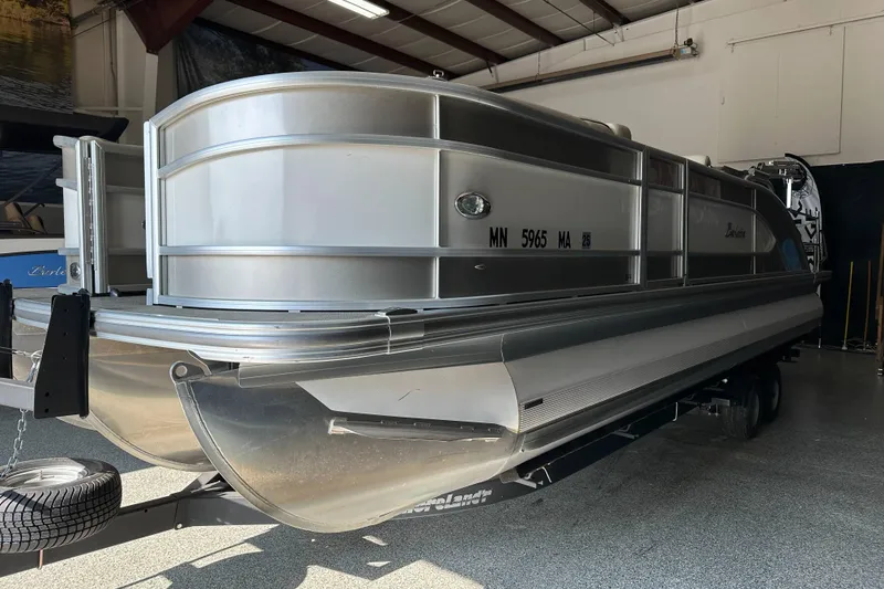 Slide: The Image of 2020 Barletta L25UE pontoon boat in showroom, rear view with motor and ladder. - 7