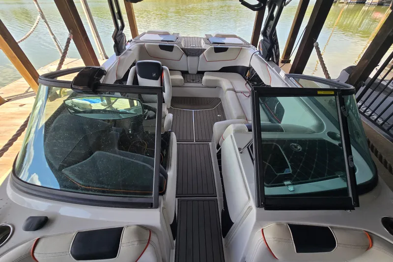 Slide: The Image of 2018 Natique GS20 boat docked under a covered structure on a serene lake. - 15