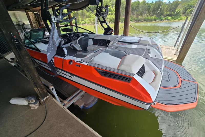 Slide: The Image of 2018 Natique GS20 boat docked in a covered marina, surrounded by scenic lake views. - 5