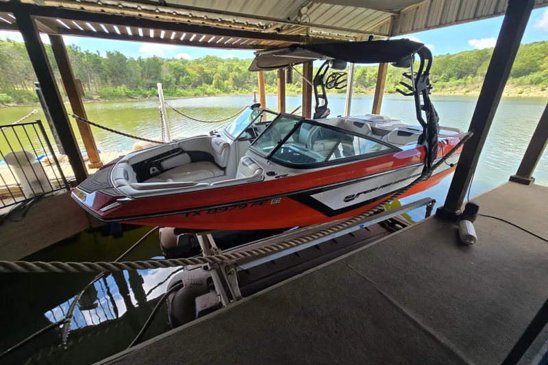 Slide: The Image of Red and white 2018 Natique GS20 boat interior docked by a serene lake. - 6