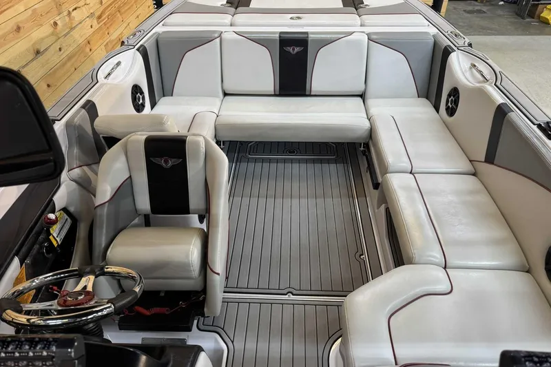 Slide: The Image of 2009 Nautique Super Air Nautique 210 Byerly boat interior with white seating and steering wheel. - 10