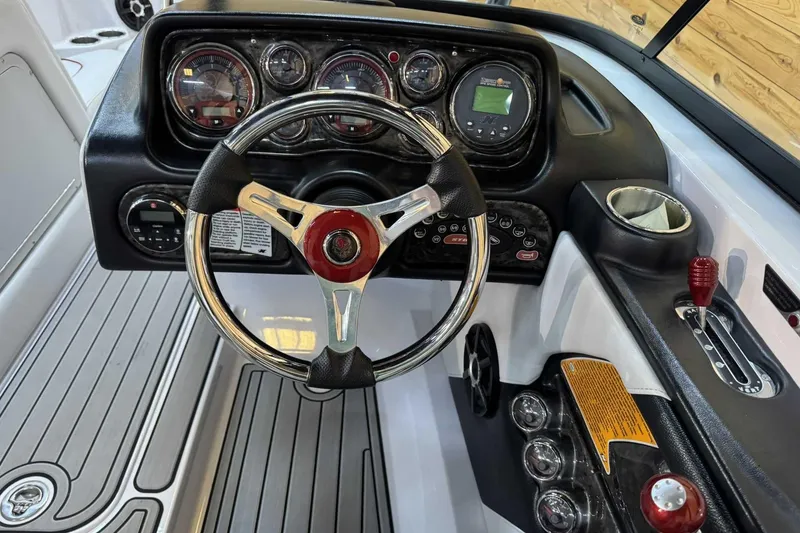 Slide: The Image of 2009 Nautique Super Air Nautique 210 Byerly dashboard with steering wheel and controls. - 11