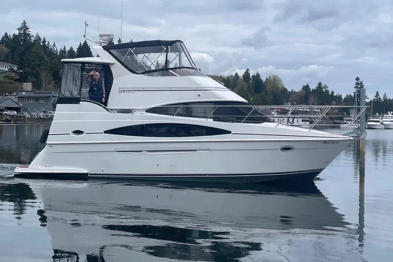 The Image of 2002 Carver 346 Aft Cabin yacht on calm water, with scenic forested background. - 0