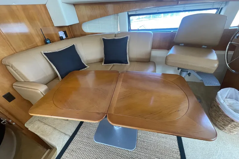 Slide: The Image of 2002 Carver 346 Aft Cabin interior with beige seating and wooden table. - 17