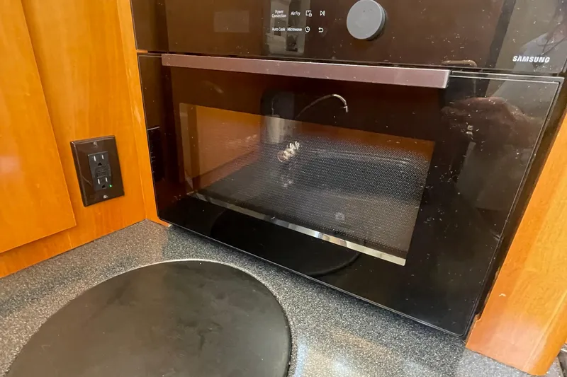 Slide: The Image of Microwave in 2002 Carver 346 Aft Cabin kitchen with wooden cabinetry. - 23