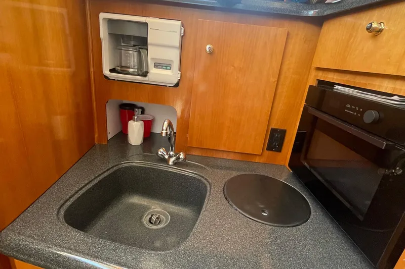 Slide: The Image of 2002 Carver 346 Aft Cabin kitchen with sink, coffee maker, and oven. - 25
