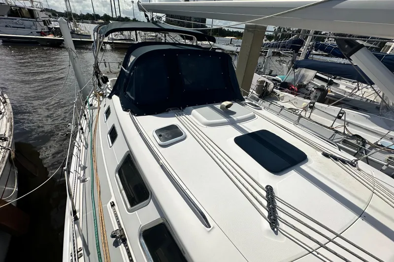 Slide: The Image of 2006 Hunter 41 Deck Salon sailboat docked at marina, featuring sleek design and spacious deck. - 16