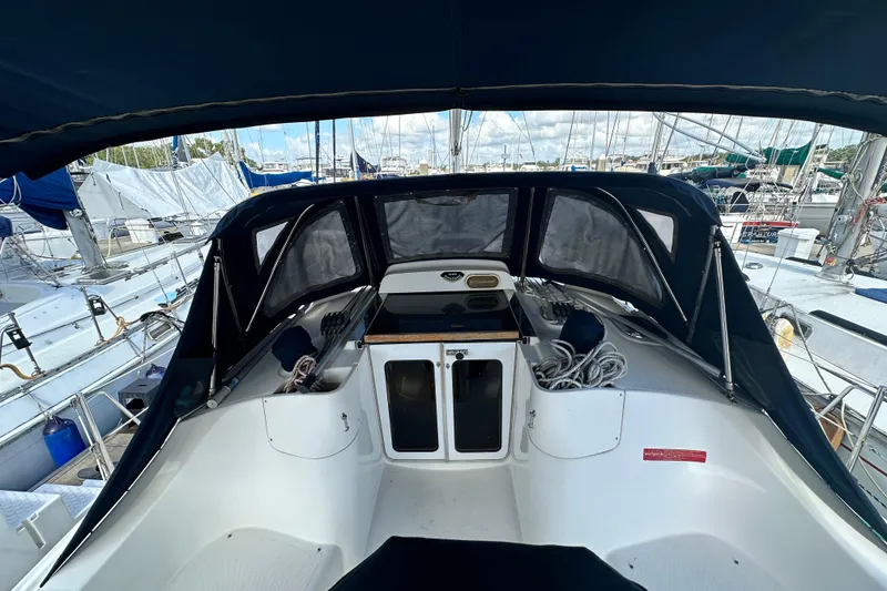 Slide: The Image of 2006 Hunter 41 Deck Salon yacht cockpit with covered seating and marina view. - 19