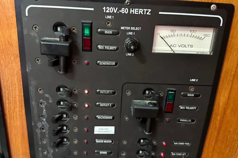 Slide: The Image of Electrical panel of a 2006 Hunter 41 Deck Salon boat, showing AC voltage meter and switches. - 26