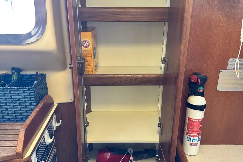 Slide: The Image of Empty wooden cabinet with fire extinguisher on a 2006 Hunter 41 Deck Salon yacht. - 28