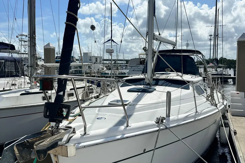 Slide: The Image of 2006 Hunter 41 Deck Salon sailboat docked at marina under cloudy sky. - 3