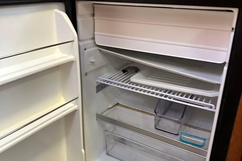 Slide: The Image of Open refrigerator inside 2006 Hunter 41 Deck Salon yacht, showing shelves and storage compartments. - 36