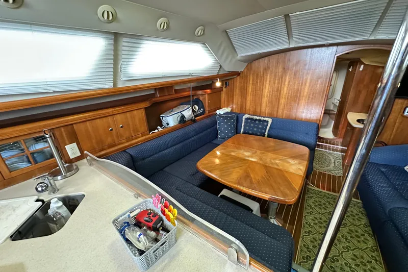 Slide: The Image of Interior of 2006 Hunter 41 Deck Salon with wooden table and blue seating. - 43