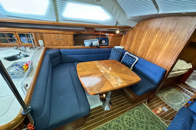 Slide: The Image of Interior of 2006 Hunter 41 Deck Salon with cozy seating and wooden table. - 46