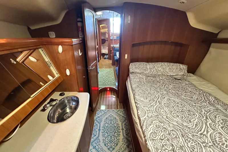 Slide: The Image of Interior of 2006 Hunter 41 Deck Salon with bed, sink, and wooden cabinetry. - 52
