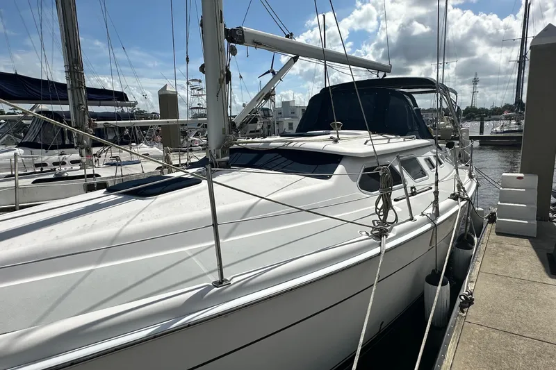 Slide: The Image of 2006 Hunter 41 Deck Salon sailboat docked at marina under cloudy sky. - 6