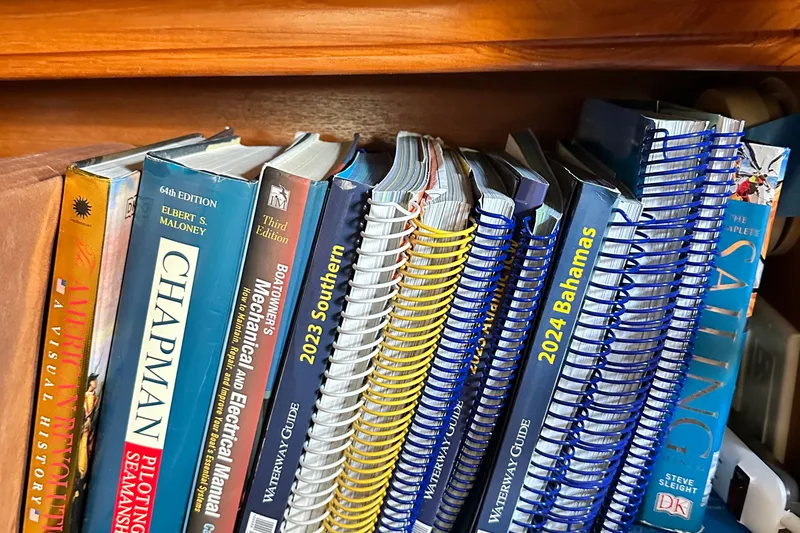 Slide: The Image of Bookshelf with nautical guides and manuals on a 2006 Hunter 41 Deck Salon yacht. - 69