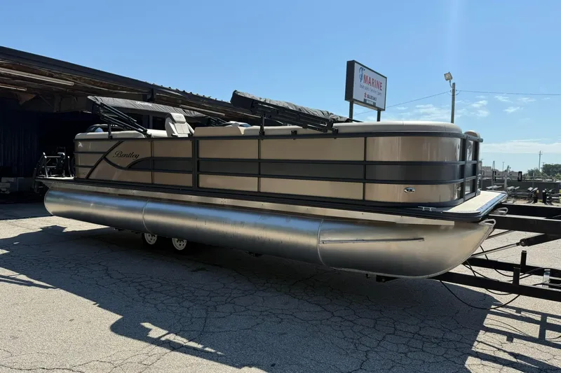 The Image of 2025 Bentley Pontoons Legacy 243 Navigator pontoon boat on trailer, outdoor setting. - 0