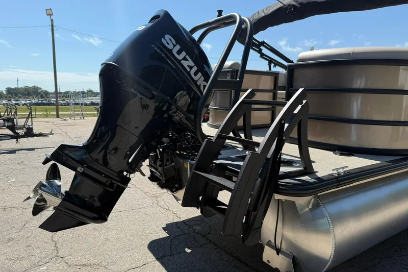 Slide: The Image of 2025 Bentley Pontoons Legacy 243 Navigator with Suzuki outboard motor, docked on pavement. - 5