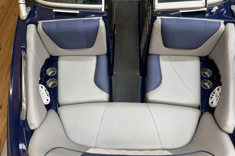 Slide: The Image of 2011 MasterCraft X2 boat interior with blue and gray seating, cup holders, and speakers. - 10