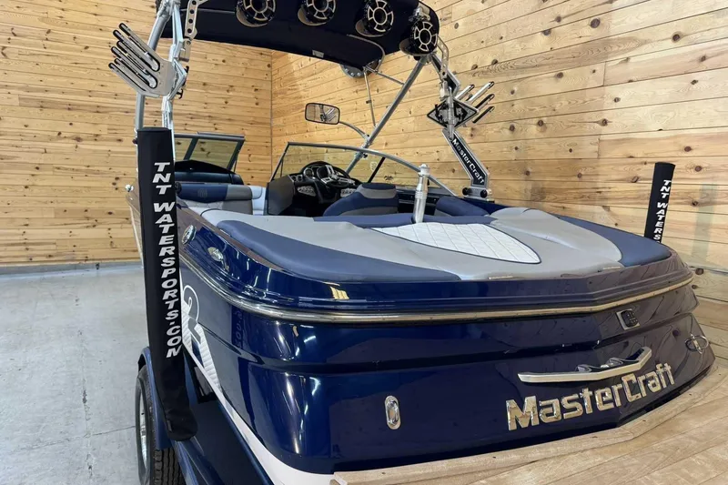 Slide: The Image of 2011 MasterCraft X2 boat in wooden garage, featuring wakeboard tower and speakers. - 4