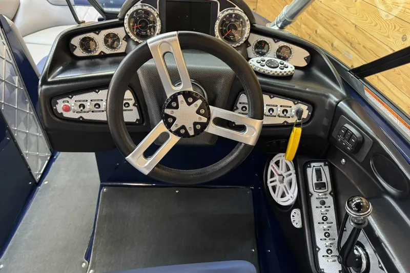 Slide: The Image of 2011 MasterCraft X2 boat dashboard with steering wheel and control panel. - 7