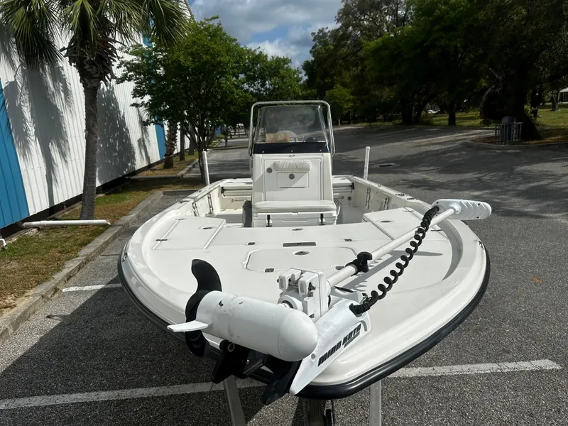 Slide: The Image of 2018 Triton 220LTS boat parked outdoors, featuring a sleek design and trolling motor. - 13